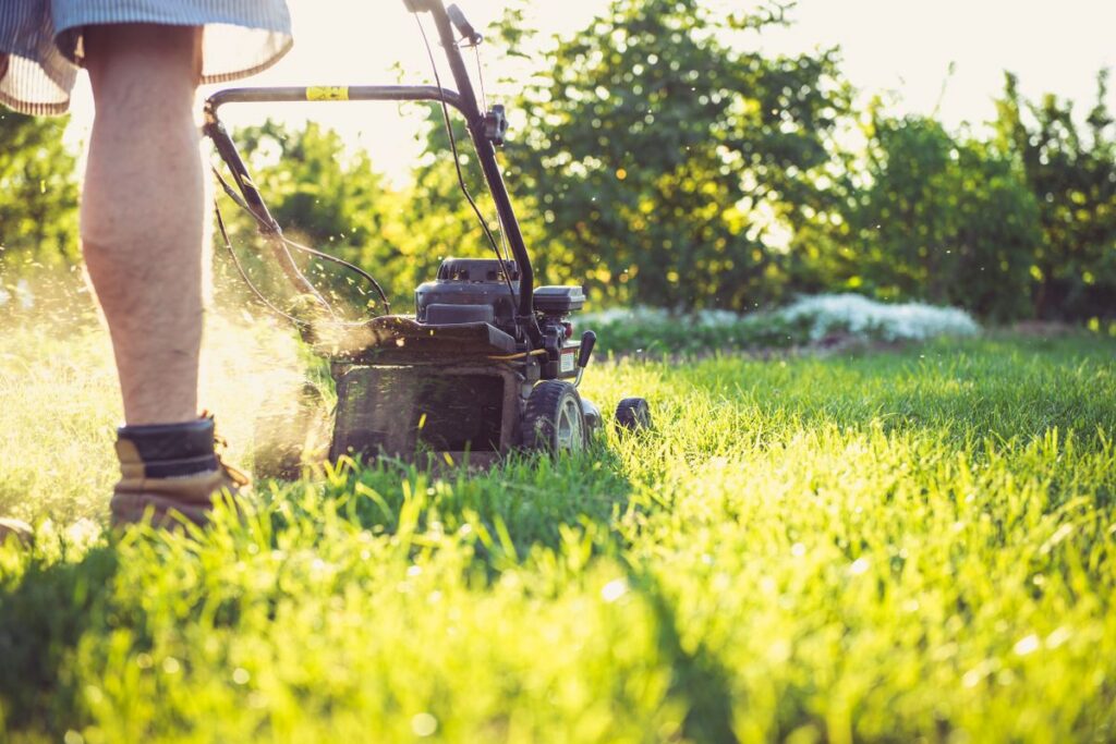 Landscaping marketing in Wayne NJ, a landscaper mowing a green suburban lawn