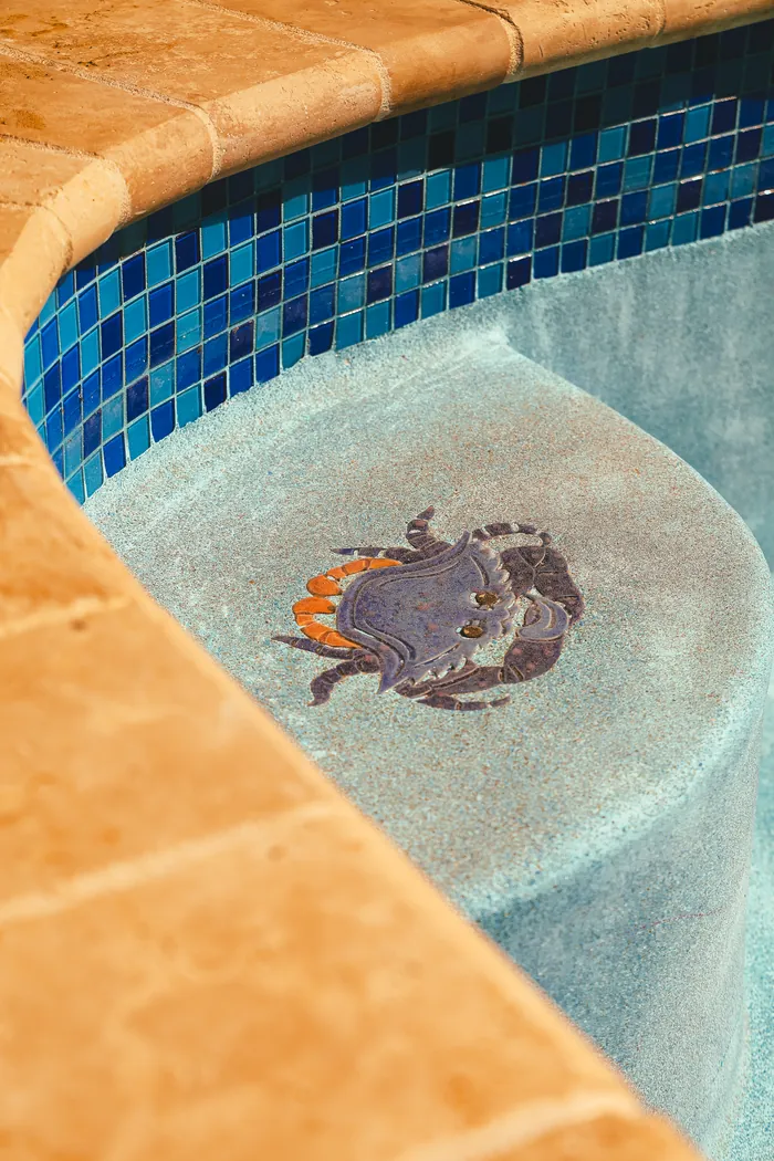 Crab mosaic tile under the water next to blue tile and stone coping in Morganville NJ