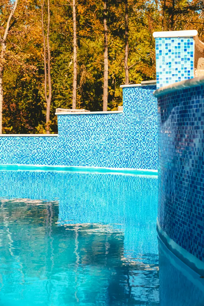 Detail of the blue glass mosaic tile on a raised pool wall in Morganville NJ